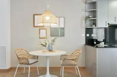 a white table with two chairs and a pendant light at Click&Flat Sugranyes in Barcelona