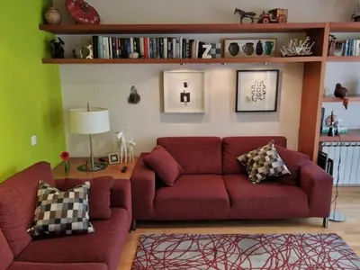 a living room with a red couch and green walls at Homing Sabadell 73 in Sabadell