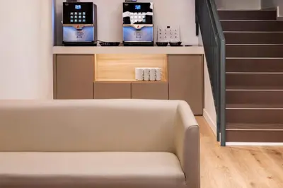 a room with a stair case with a shelf with bottles on it at B&B HOTEL Barcelona Sant Cugat in Sant Cugat del Vallès