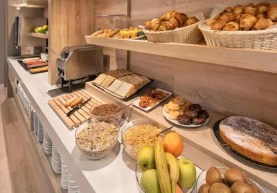 a buffet line with different types of bread and pastries at B&B HOTEL Barcelona Sant Cugat in Sant Cugat del Vallès