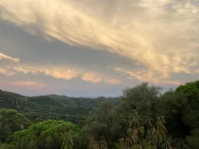 a cloudy sky above a forest with trees at Casa con vista y jardín, a 20' de la playa in Sant Cebrià de Vallalta