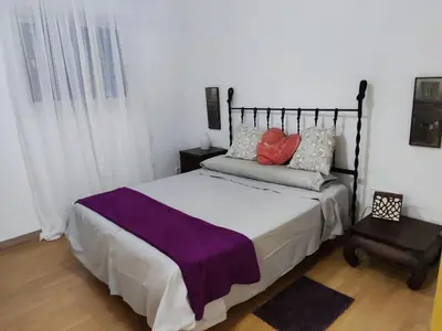 a bedroom with a large bed and a chair at Apartamento a 10Km Barcelona, Jardin, Luminoso in Martorellas