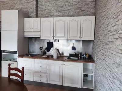 a white kitchen with white cabinets and a table at Apartamento a 10Km Barcelona, Jardin, Luminoso in Martorellas