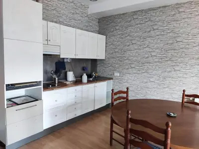 a kitchen with white cabinets and a brick wall at Apartamento a 10Km Barcelona, Jardin, Luminoso in Martorellas
