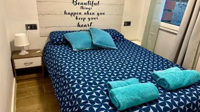 a bedroom with a bed with blue pillows on it at Apartamento playa in Arenys de Mar