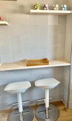 two white stools sitting under a counter in a kitchen at Apartamento playa in Arenys de Mar