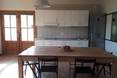a kitchen with a wooden table with a bowl of fruit on it at Wonderful house in the mountains with sea views in Cabrils
