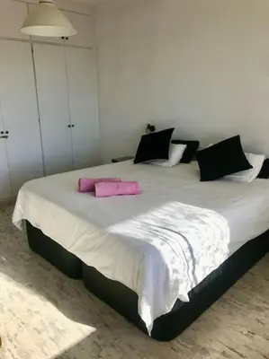 a bedroom with a large bed with pink pillows at Wonderful house in the mountains with sea views in Cabrils