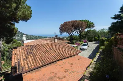 a car parked on a street next to a house at Wonderful house in the mountains with sea views in Cabrils