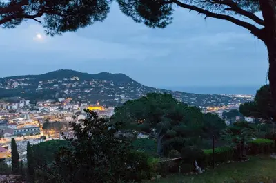 a view of a city from a hill with trees at Wonderful house in the mountains with sea views in Cabrils