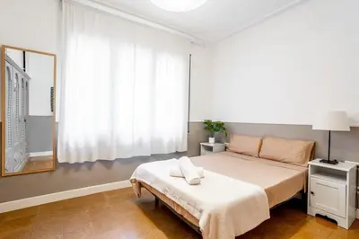 a bedroom with a bed and a mirror and a window at The Collection Barcelona - Sants Estacio - Modern and comfy 4BD for 8 guests in Barcelona
