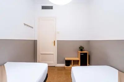 two beds in a small room with a door at The Collection Barcelona - Sants Estacio - Modern and comfy 4BD for 8 guests in Barcelona