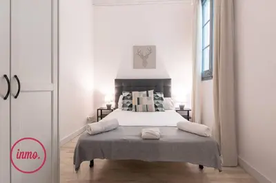 a bedroom with a bed in a white room at Barcelona - Eixample 2 in Barcelona