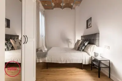 a white bedroom with a bed and a window at Barcelona - Eixample 2 in Barcelona