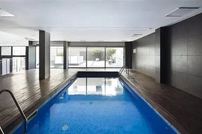 a swimming pool with blue water in a building at Cozy apartment Forum beach in Sant Adria de Besos