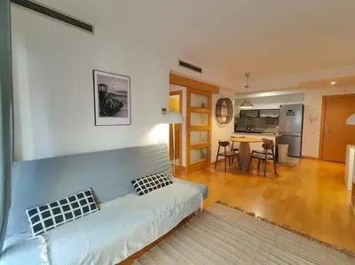 a living room with a couch and a kitchen at Cozy apartment Forum beach in Sant Adria de Besos