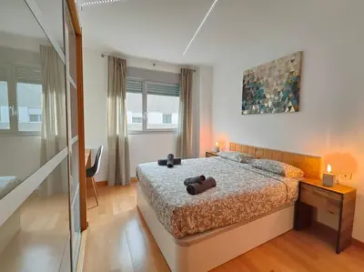 a bedroom with a bed and a table with two lamps at Cozy apartment Forum beach in Sant Adria de Besos