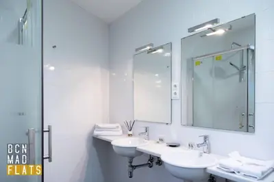 a white bathroom with two sinks and a mirror at Bcn - Sagrada Familia in Barcelona