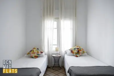 two beds in a small room with a window at Bcn - Sagrada Familia in Barcelona