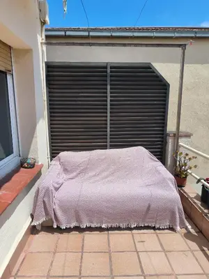 a pink blanket is sitting on the outside of a garage at La casita de Pe Beach in Premiá de Mar