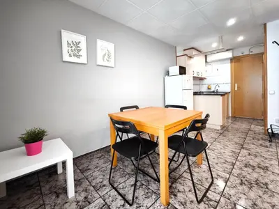 a kitchen with a wooden table and chairs at Apartamento loft en Castelldefels junto la playa in Castelldefels