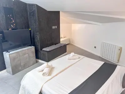 a bedroom with a bed and a flat screen tv at Sitges Port View Apartment by Hello Homes Sitges in Sitges