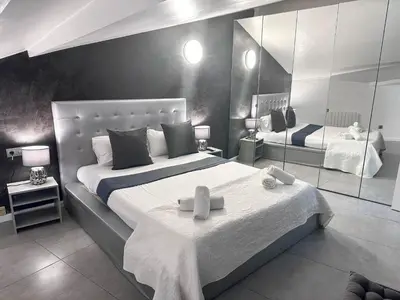 a bedroom with a large bed and a mirror at Sitges Port View Apartment by Hello Homes Sitges in Sitges