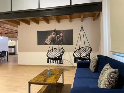 a living room with a blue couch and two chairs at Manresa industrial home in Manresa