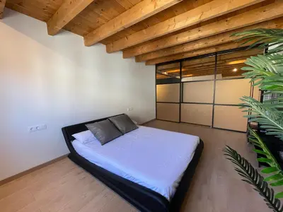 a bed in a room with a wooden ceiling at Manresa industrial home in Manresa