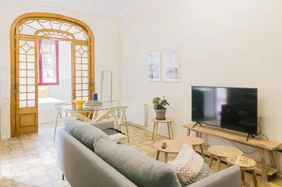 a living room with a couch and a tv at Aticco Living Gràcia - Apartments Rooftop in Barcelona