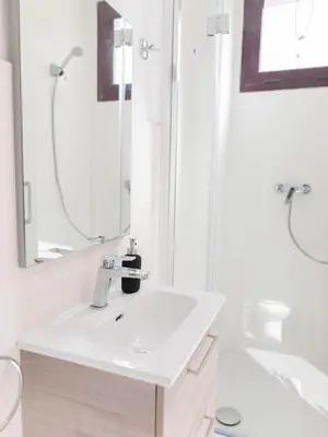 a white bathroom with a sink and a shower at Aticco Living Gràcia - Apartments Rooftop in Barcelona
