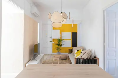 a living room with a yellow accent wall at Aticco Living Gràcia - Apartments Rooftop in Barcelona