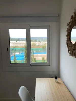 a dining room with a table and two windows at Apartment Llavaneres near Barcelona Beach Pool in Sant Andreu de Llavaneres