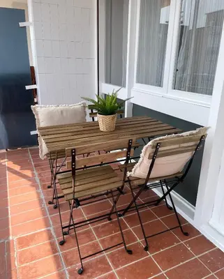 a wooden table and a chair on a porch at Apartment Llavaneres near Barcelona Beach Pool in Sant Andreu de Llavaneres