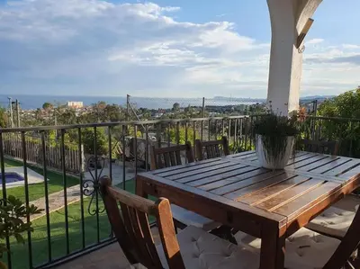 a wooden table on a balcony with a view at Casa con gran jardín y unas preciosas vistas in Teià