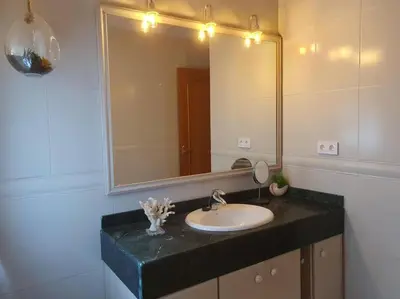 a bathroom with a sink and a mirror at Casa con gran jardín y unas preciosas vistas in Teià