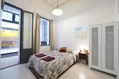 a bedroom with a bed and a table and a window at Parallel-Patio in Barcelona