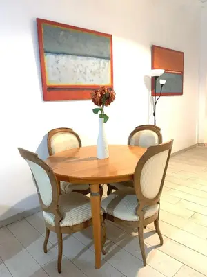 a wooden table with chairs and a vase with flowers on it at Parallel-Patio in Barcelona