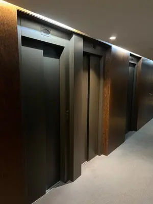 a row of black elevator doors in a building at APARTMENT JUST 100mts FROM GAUDI'S CASA MILÀ-la Pedrera in Barcelona