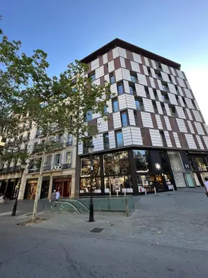 a tall building with a tree in front of it at APARTMENT JUST 100mts FROM GAUDI'S CASA MILÀ-la Pedrera in Barcelona