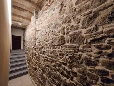 a stone wall in a hallway with a staircase at Antic Manresa 2 in Manresa