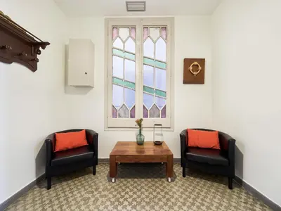 two chairs and a table in a room with a window at Belvilla by OYO Rambla Paris Apartment in Barcelona