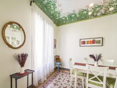 a dining room with a table and a mirror at Belvilla by OYO Rambla Paris Apartment in Barcelona