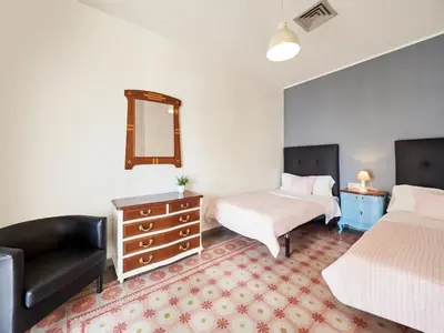 a bedroom with two beds and a couch and a mirror at Belvilla by OYO Rambla Paris Apartment in Barcelona