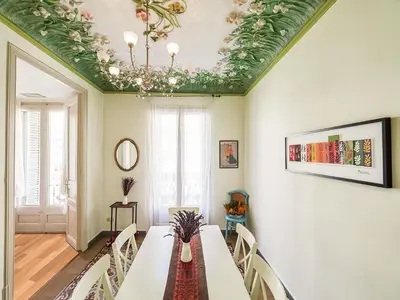 a dining room with a table and a chandelier at Belvilla by OYO Rambla Paris Apartment in Barcelona