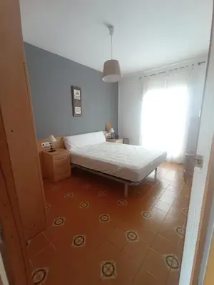 a bedroom with a bed in a room with a window at Apartamento, 3° línea de playa in Cubelles
