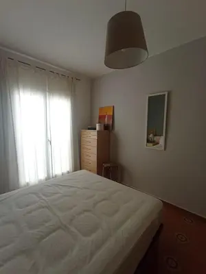 a bedroom with a white bed and a window at Apartamento, 3° línea de playa in Cubelles