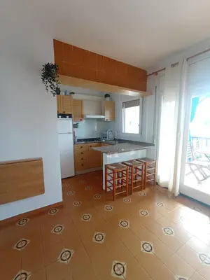 a kitchen with a table and some chairs in it at Apartamento, 3° línea de playa in Cubelles