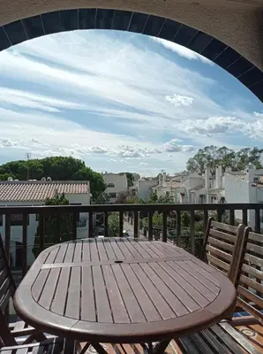 a wooden table and two chairs on a balcony at Apartamento, 3° línea de playa in Cubelles