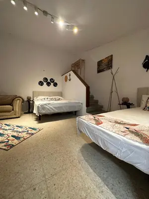a room with two beds and a couch and a staircase at Hidden garden Central and quiet rest in Barcelona